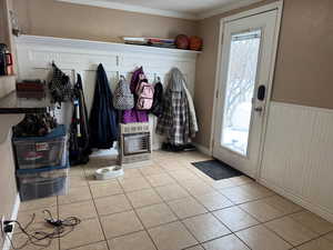 Mudroom featuring light tile patterned floors, wainscoting, plenty of natural light, and heating unit