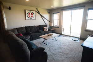Carpeted living room with a healthy amount of sunlight and recessed lighting
