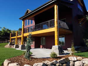 Rear view of house with a patio area and a lawn
