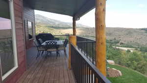 Wooden deck featuring a mountain view and outdoor dining space