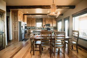 Dining room featuring an inviting chandelier, light wood-style flooring, beamed ceiling, and recessed lighting
