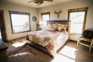 Bedroom featuring ceiling fan, multiple windows, carpet, and baseboards