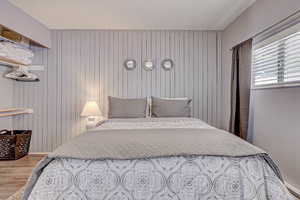 Bedroom with wooden walls and wood finished floors