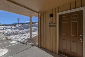 Snow covered property entrance featuring board and batten siding