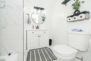 Bathroom with baseboards, vanity, and toilet