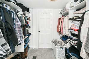 Walk in closet with light colored carpet