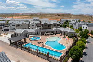 Community pool with a mountain view, a patio, fence, and a residential view