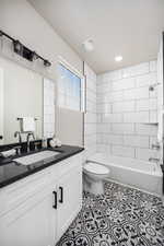 Bathroom with visible vents, toilet, vanity, shower / tub combination, and tile patterned flooring