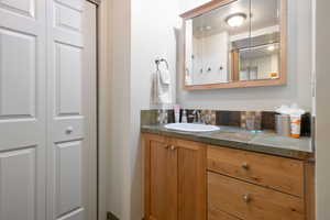 Full bath with a closet, backsplash, and vanity