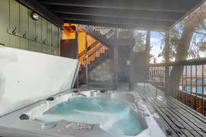 Deck with a covered hot tub and stairway