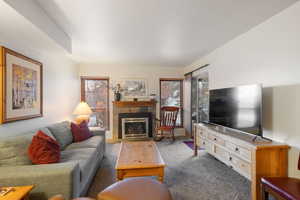 Living area with a tiled fireplace and carpet flooring