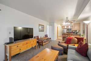 Living room featuring a ceiling fan and light carpet