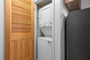 Laundry room featuring laundry area and stacked washer / drying machine