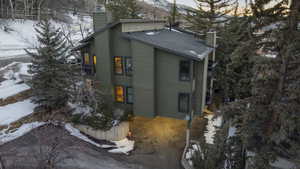 View of snow covered exterior featuring a chimney and a mountain view