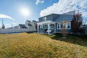 Back of house with a shingled roof, a fenced backyard, a yard, a patio area, and a pergola