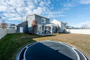 View of front of home with a patio, a fenced backyard, a gate, a pergola, and a front yard