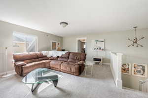 Living room with light carpet, visible vents, and baseboards