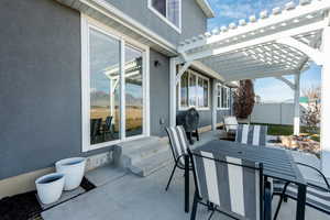 View of patio / terrace with entry steps, fence, grilling area, a pergola, and outdoor dining space