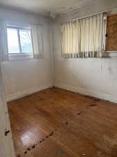 Unfurnished room with wood finished floors and baseboards