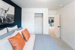 Bedroom featuring baseboards, a closet, and light colored carpet