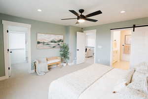 Bedroom featuring a barn door, baseboards, light colored carpet, and recessed lighting