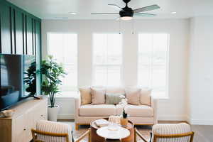 Living room with baseboards, light wood-style floors, recessed lighting, and a healthy amount of sunlight