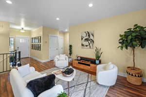 Living area with baseboards, dark wood-type flooring, and recessed lighting