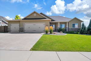 View of front of property featuring a garage, stone siding, driveway, and stucco siding