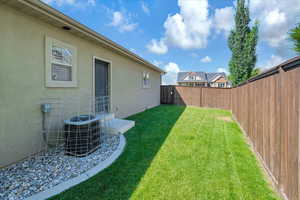 View of yard featuring central AC and a fenced backyard