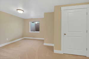 Unfurnished room with light colored carpet and baseboards