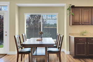 Dining room featuring light wood-type flooring, plenty of natural light, and baseboards