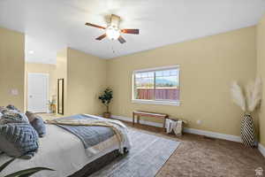 Bedroom with carpet flooring, ceiling fan, visible vents, and baseboards