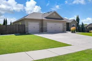 Ranch-style home with an attached garage, fence, concrete driveway, stucco siding, and a front yard