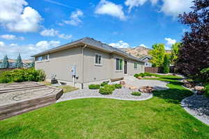 Rear view of house featuring a patio, fence, a lawn, and stucco siding