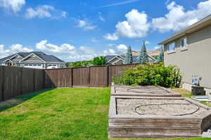 View of yard featuring a fenced backyard and a garden