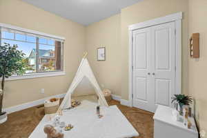 Game room with carpet flooring, visible vents, and baseboards