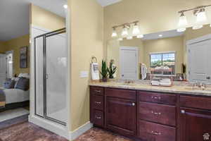 Full bathroom featuring a stall shower, a sink, and ensuite bath