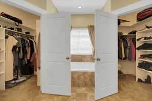 Walk in closet with light colored carpet