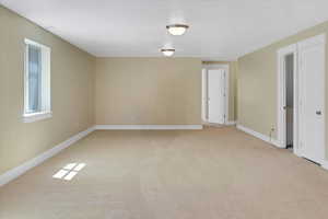 Empty room with light carpet and baseboards