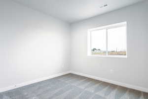 Unfurnished room with carpet, visible vents, and baseboards