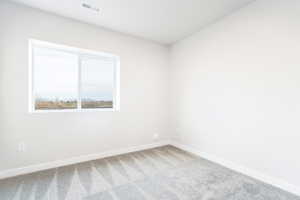 Carpeted empty room with baseboards and visible vents