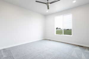 Carpeted spare room with baseboards, visible vents, ceiling fan, and recessed lighting