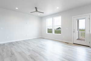 Spare room featuring visible vents, a healthy amount of sunlight, light wood finished floors, and baseboards