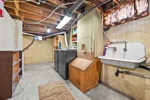 Basement featuring separate washer and dryer and sink