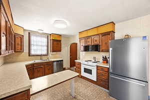 Kitchen featuring sink, decorative backsplash, and stainless steel appliances