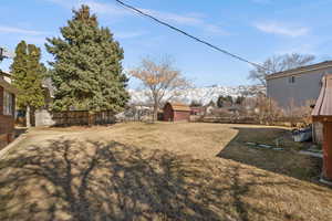 View of yard with a mountain view and a shed