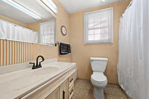 Bathroom with tile patterned floors, toilet, and vanity