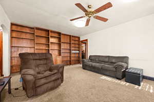 Carpeted living room with ceiling fan