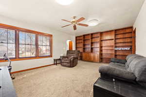 Carpeted living room featuring ceiling fan