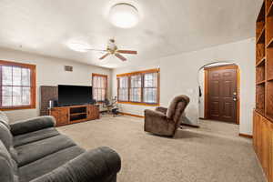 Living room with light carpet and ceiling fan